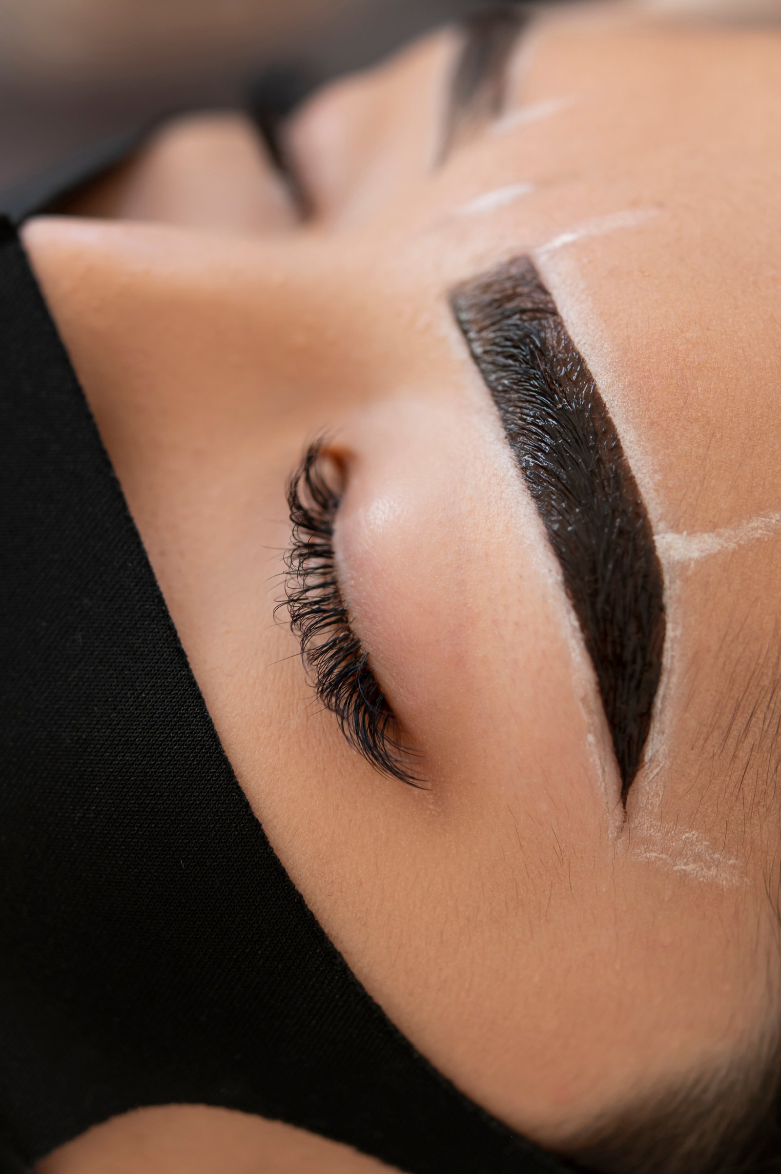 Expert artist performing precise eyebrow microblading stroke treatment at Hues Aesthetic Clinic Madurai