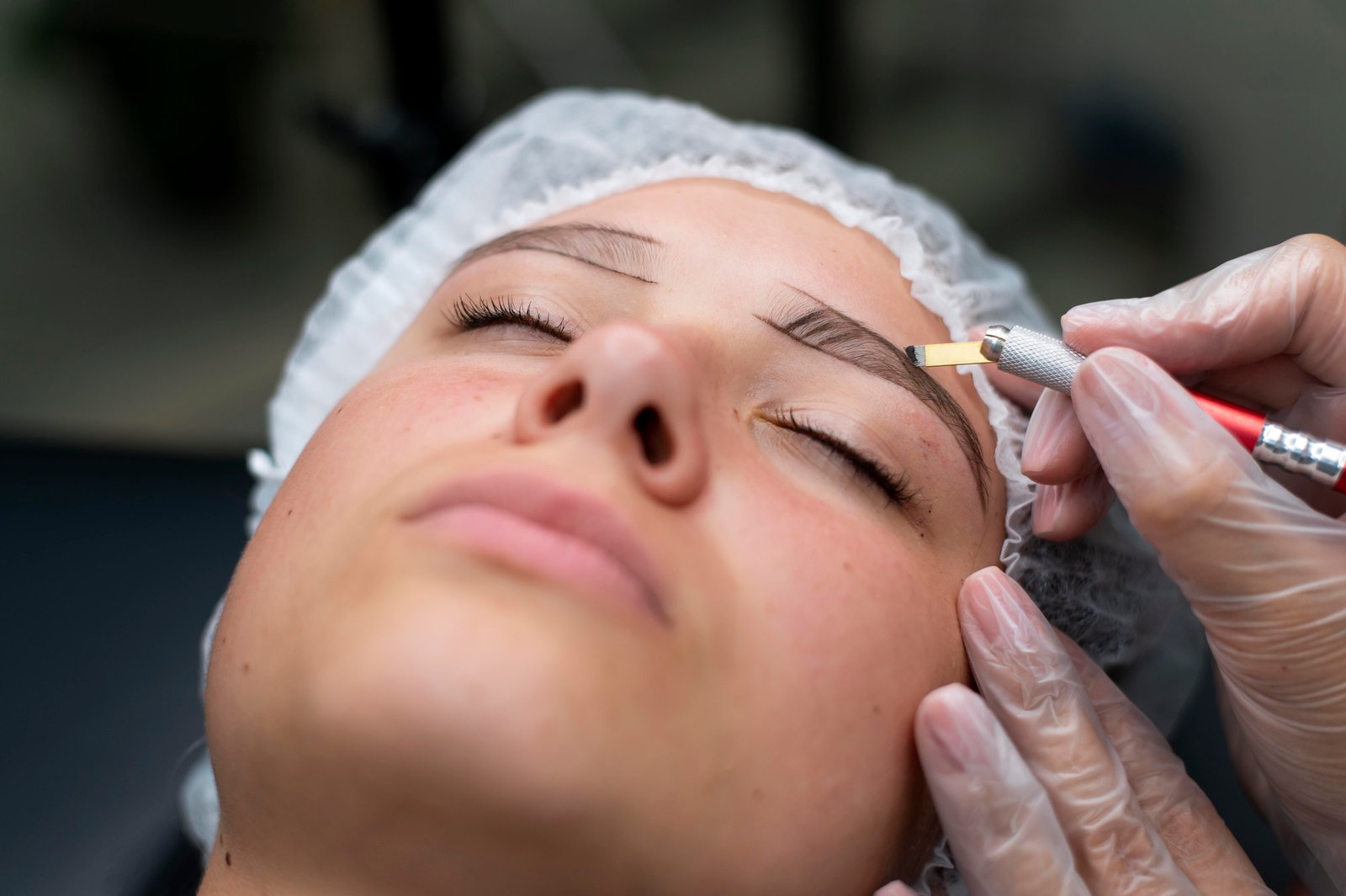 Expert artist performing precise eyebrow microblading stroke treatment at Hues Aesthetic Clinic Madurai